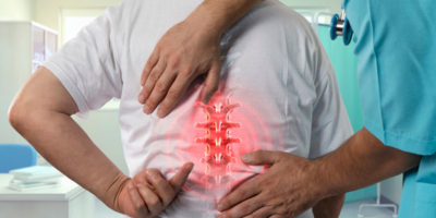 Patient Showing Doctor Back Pain And Needs Regenerative Medicine Treatment