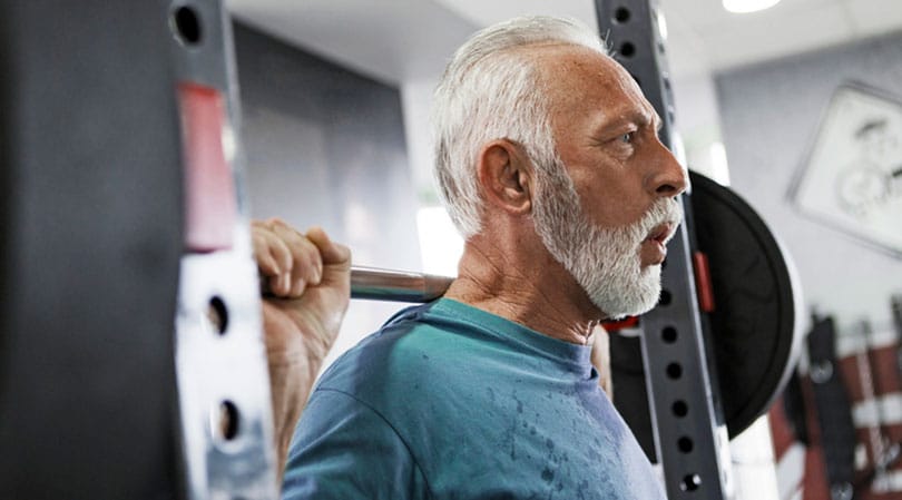 Older man lifting weights with no back pain.