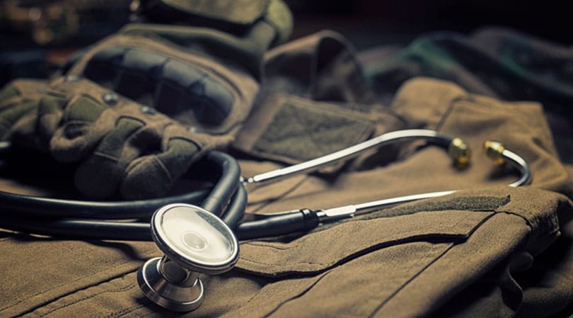 Closeup of army camouflage and stethoscope.
