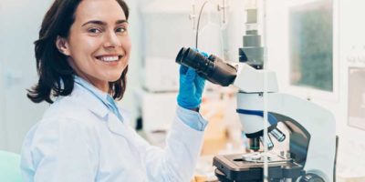 Woman doctor smiling with microscope.