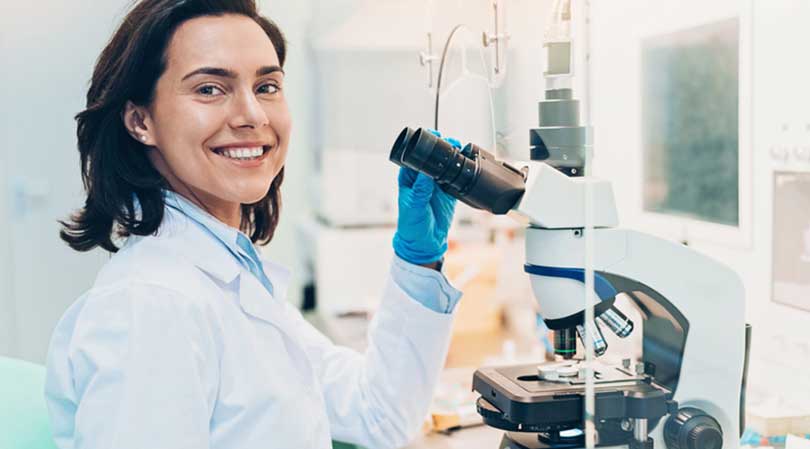 Woman doctor smiling with microscope.