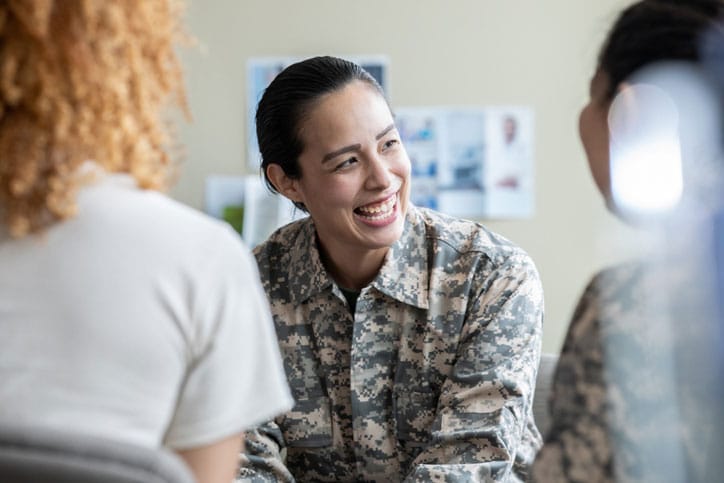 Adult military woman smiling during group therapy discussion