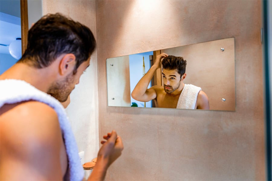 Man Looking in Mirror at Hair