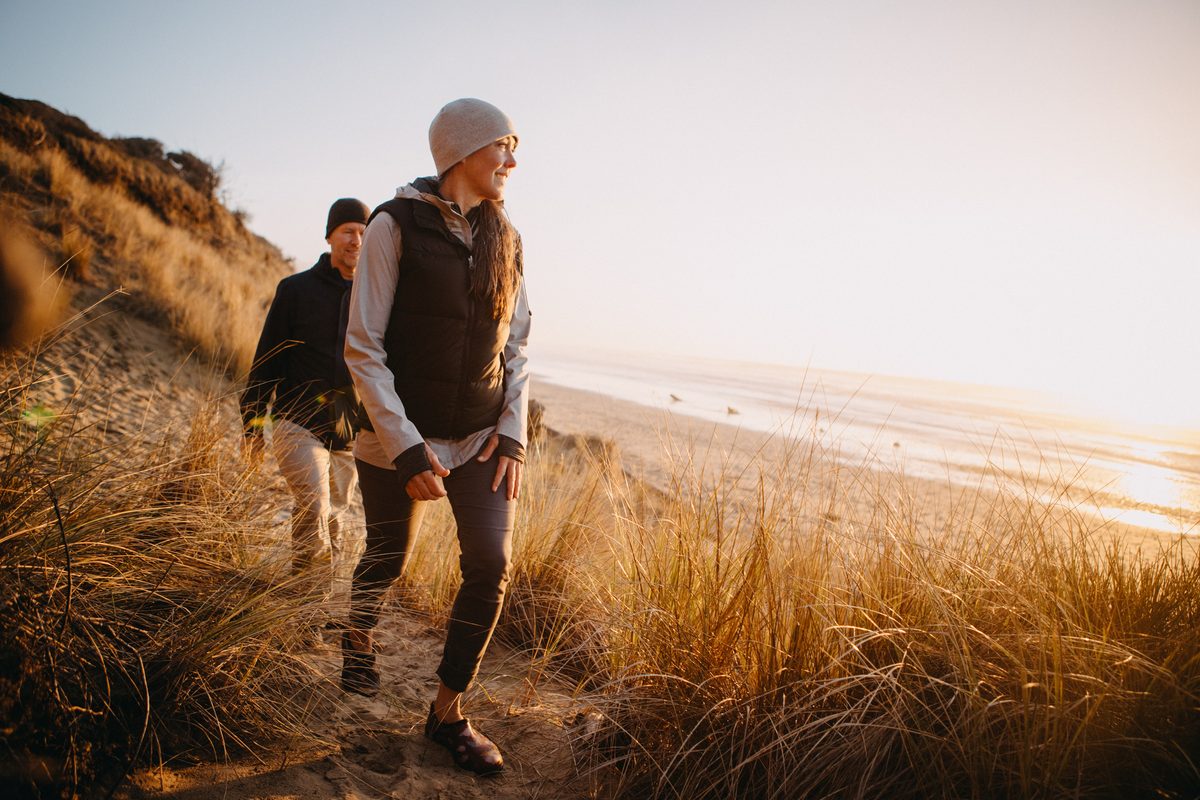 Couple hiking a coastal trail at sunset