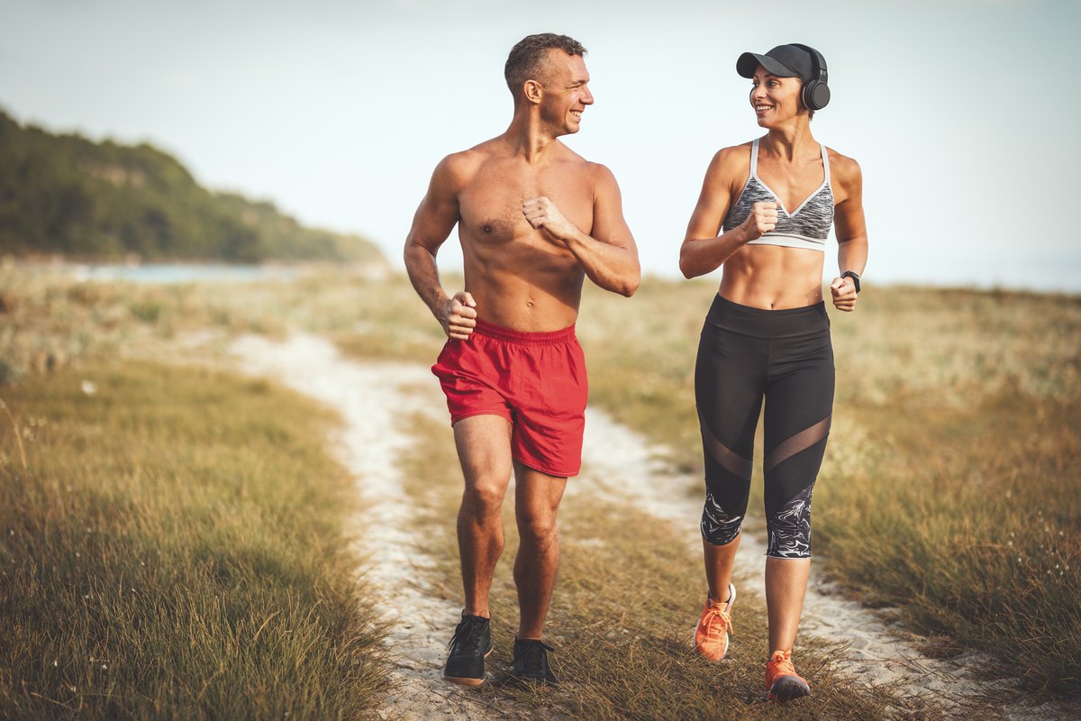 Couple running along a beach trail