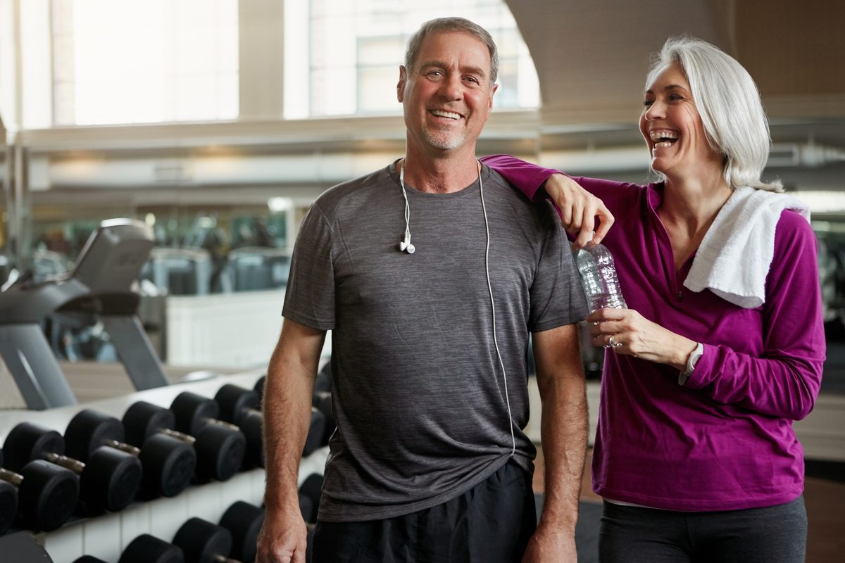 Couple smiling together during a workout at the gym