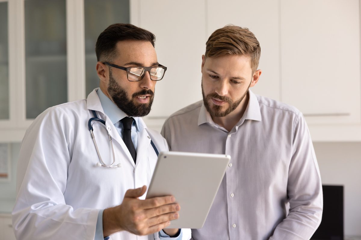 A doctor and patient review results together while standing in the clinic