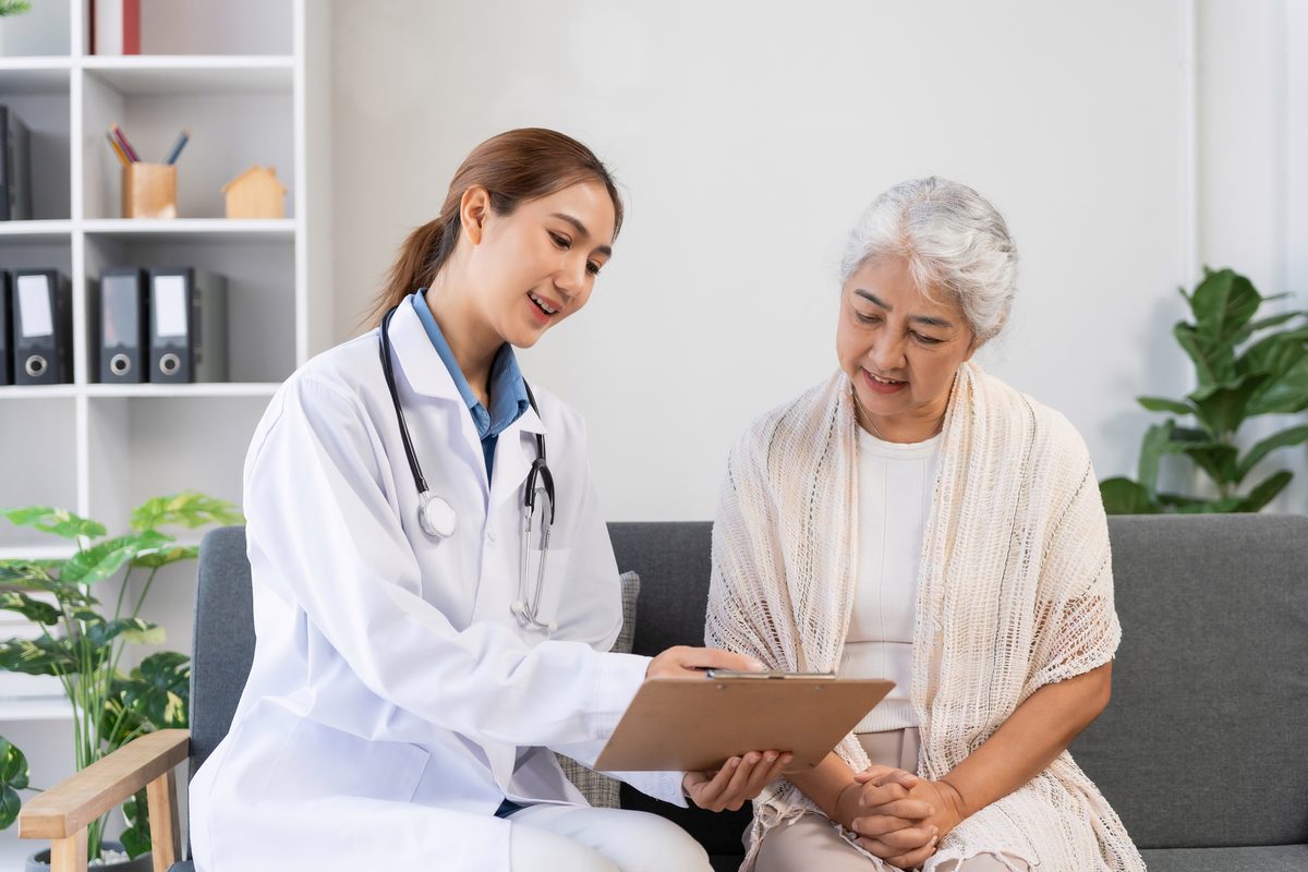 A doctor reviews a clipboard with an older woman