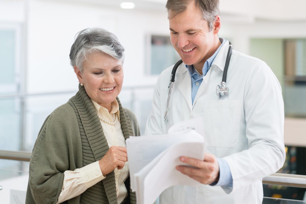 A doctor reviews paperwork with an older woman