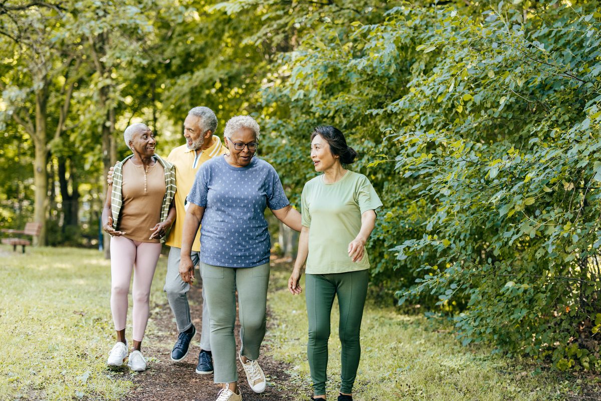Friends walking together through a park
