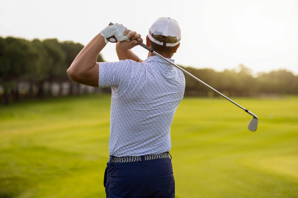 Golfer mid-swing on the course