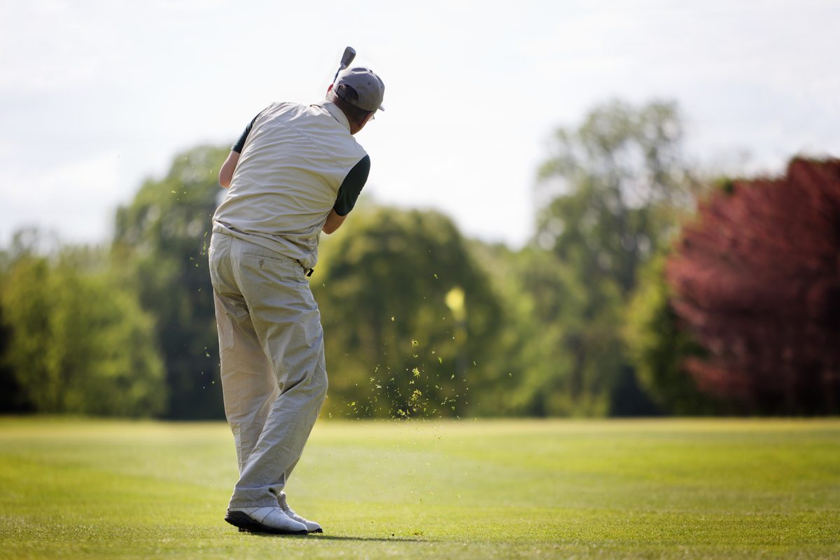 Golfer swinging on the fairway