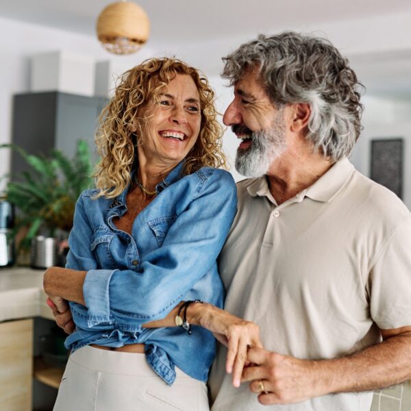 Happy middle-aged couple smiling together in their kitchen