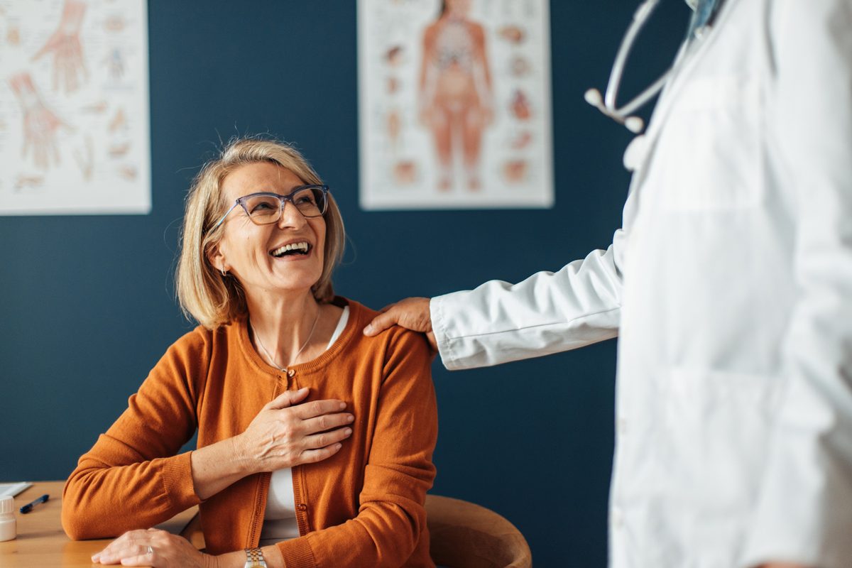 A woman laughs with her doctor during a friendly checkup