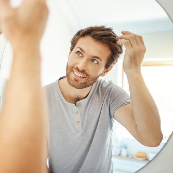 Man checking his hairline in a mirror