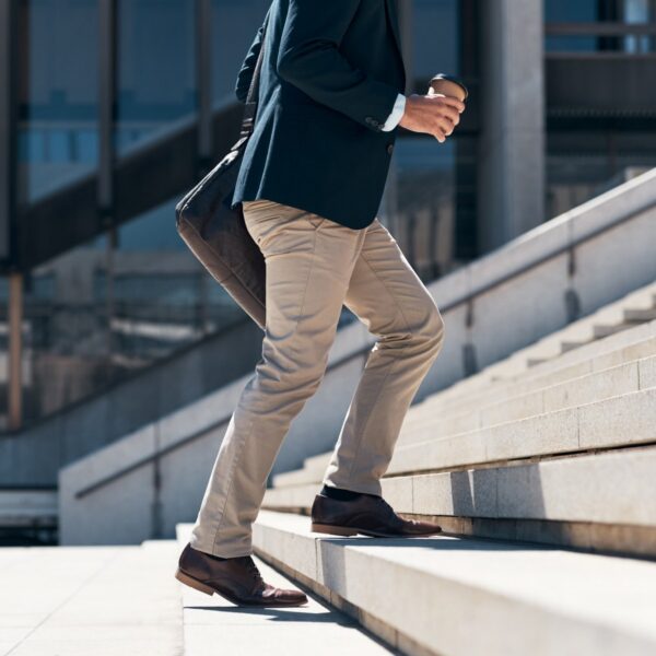Close-up of legs and knees climbing outdoor stairs