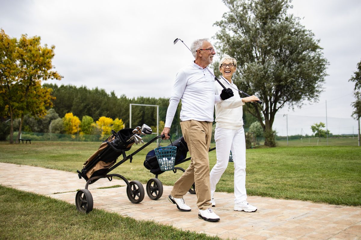 Older couple smiling together on a golf course