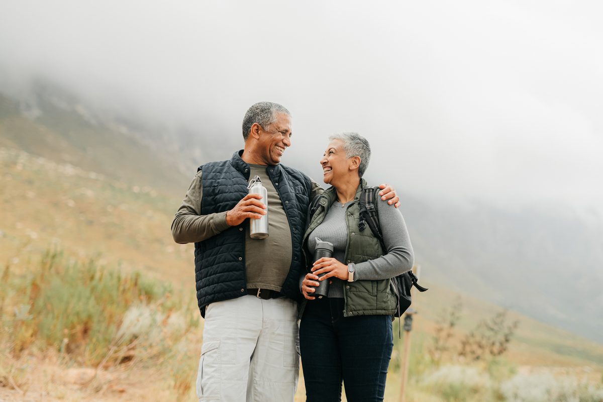 Older couple hiking together on a misty mountain trail