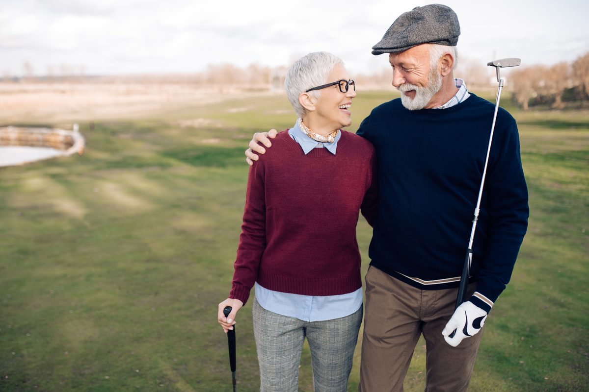 Senior couple laughing on a golf course