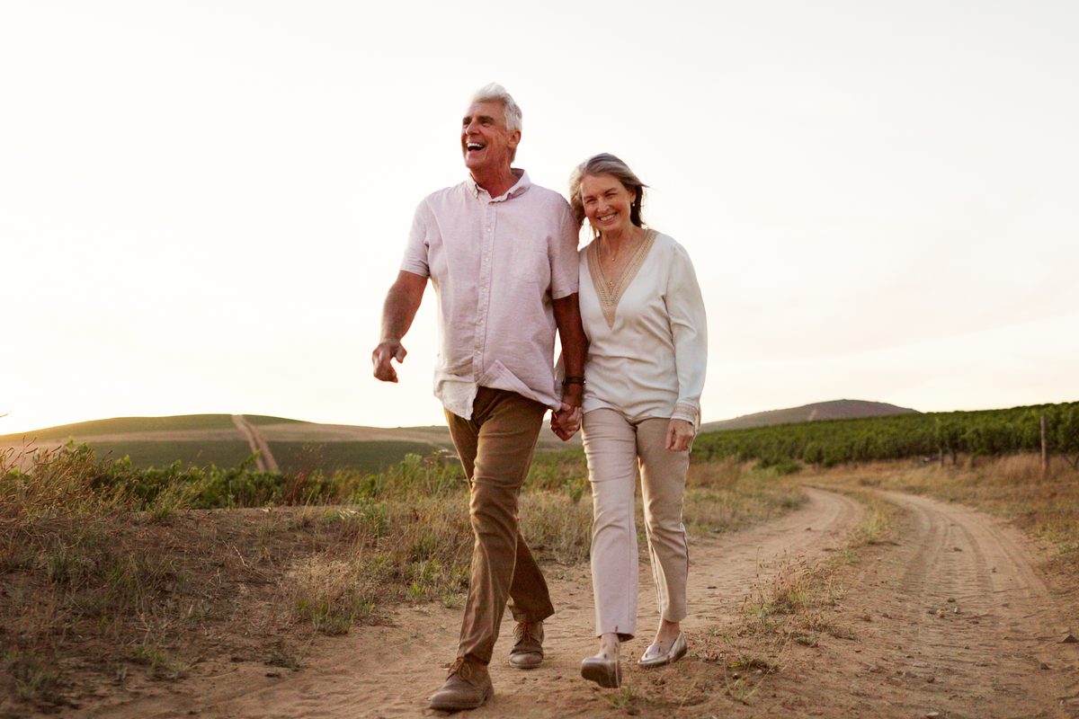 Senior couple walking a country road at sunset