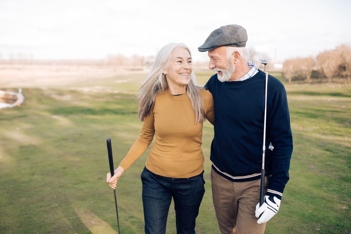 Senior couple walking a golf course together