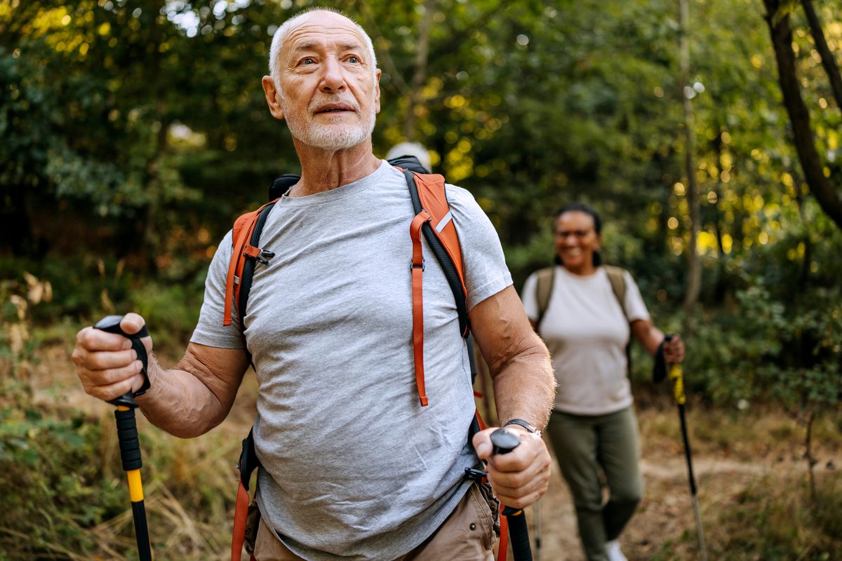 Senior man hiking with trekking poles