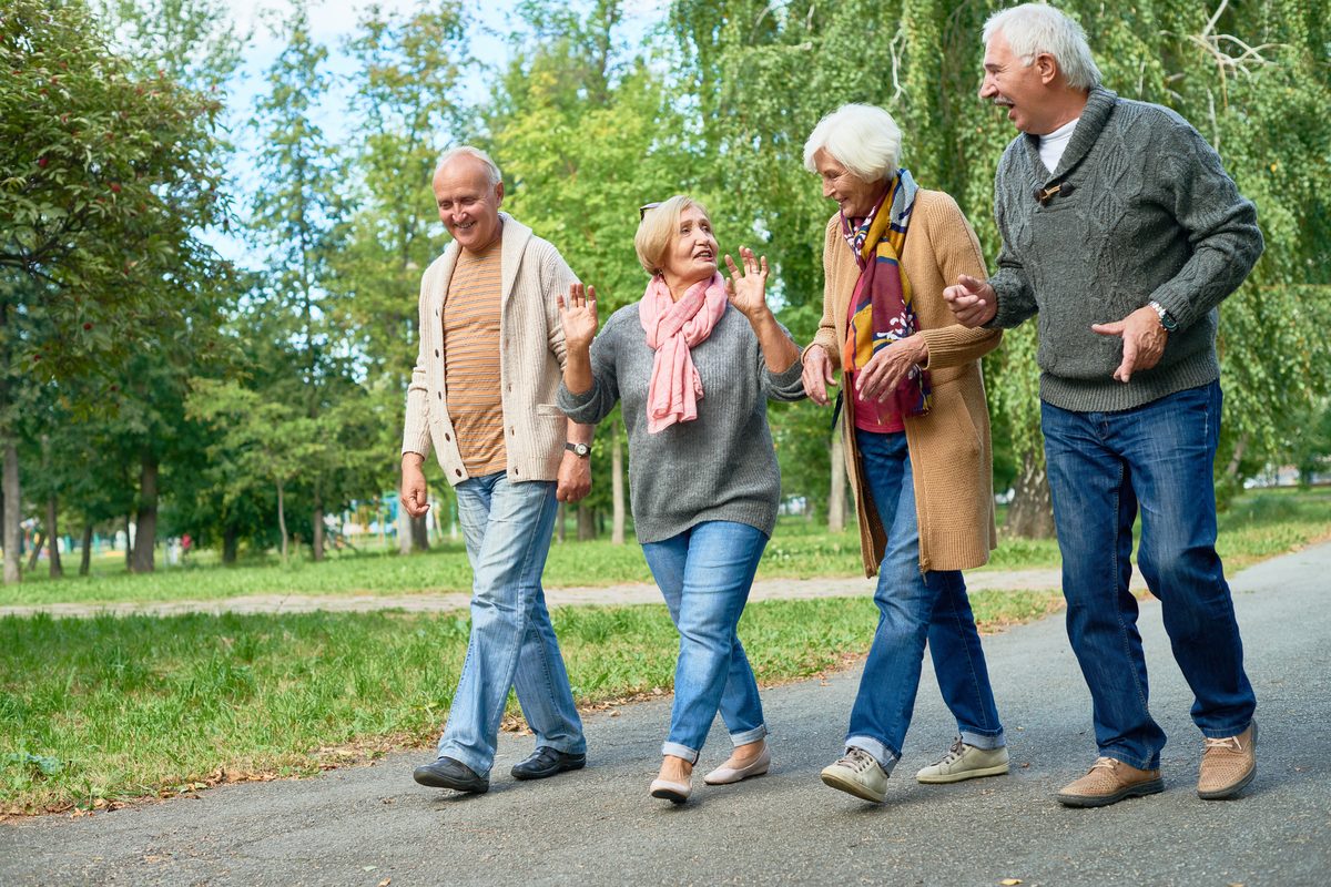 Seniors laughing together on a park walk