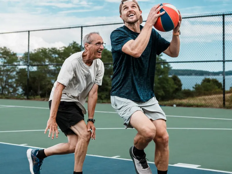 Two men playing basketball on an outdoor court