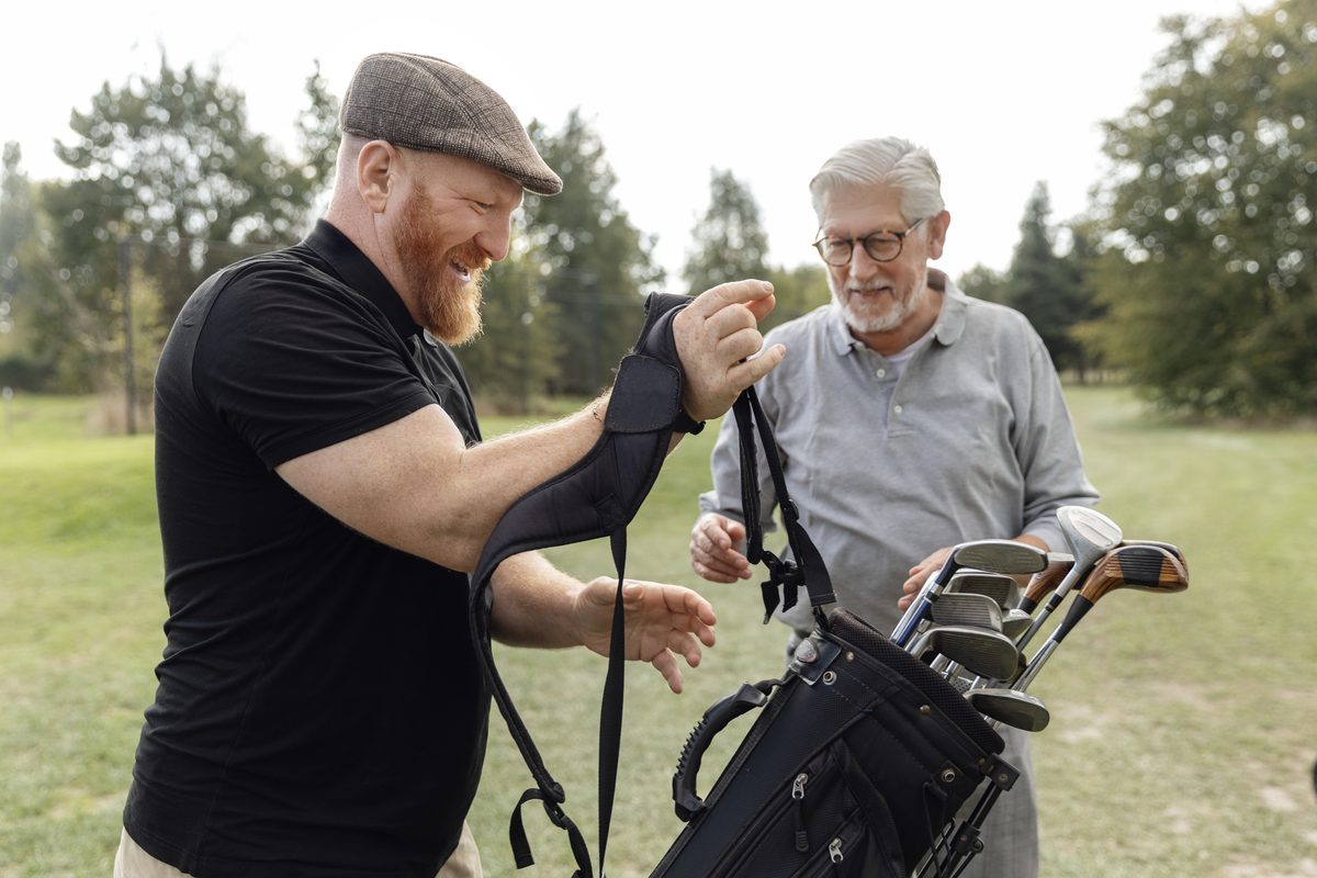Two men unpacking golf clubs
