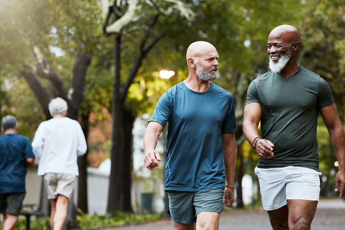 Two men walking through the park together