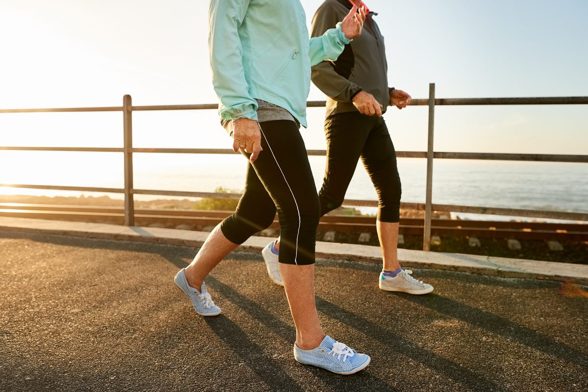 Two women power walking by the water