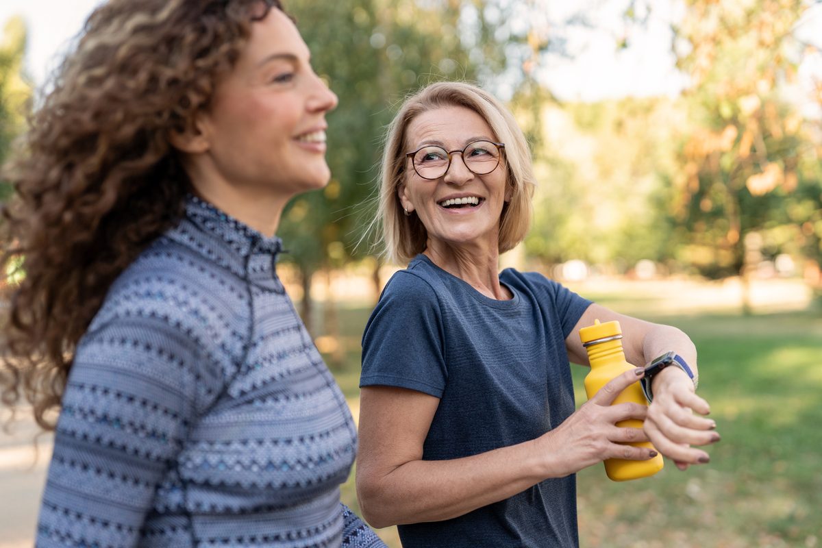 Two women check a watch during a walk